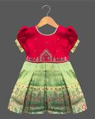 Detailed shot of a baby girl ethnic silk frock featuring traditional floral embroidery and puff sleeves.