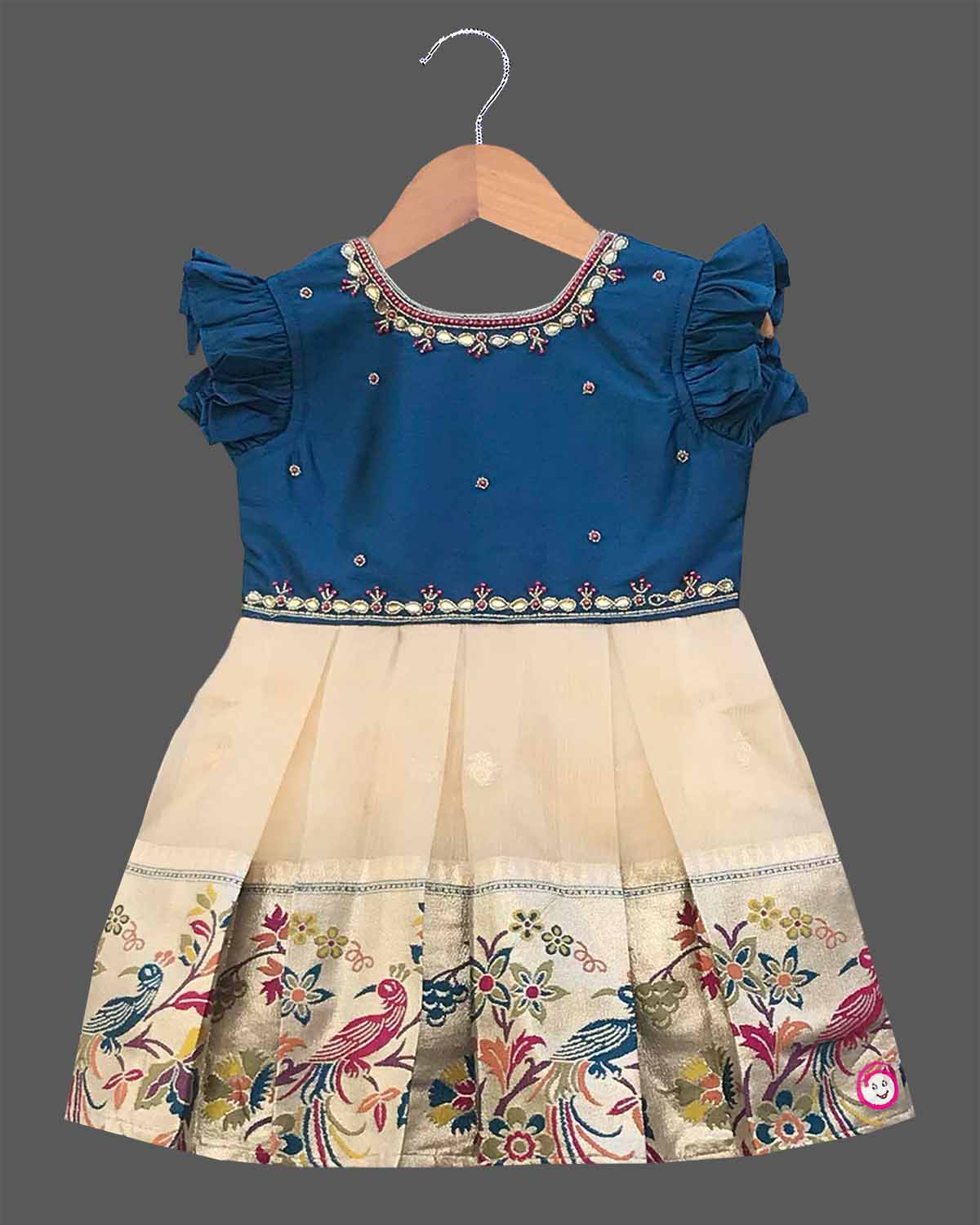 Infant cotton silk  frock in teal blue and cream with multicolored bird and floral kalamkari border work, neckline embroidery, and ruffle sleeves