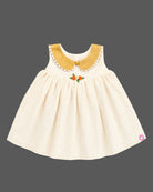Sleeveless festive ethnic frock for toddler girls featuring a scalloped Peter Pan collar and small floral bodice detail.