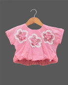 Textured floral applique blouson top paired with embroidered tiered skirt baby party wear dress.