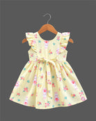 Toddler girl printed cotton A-line frock featuring ruffle shoulders, waist tie bow, and delicate lace badge accent.