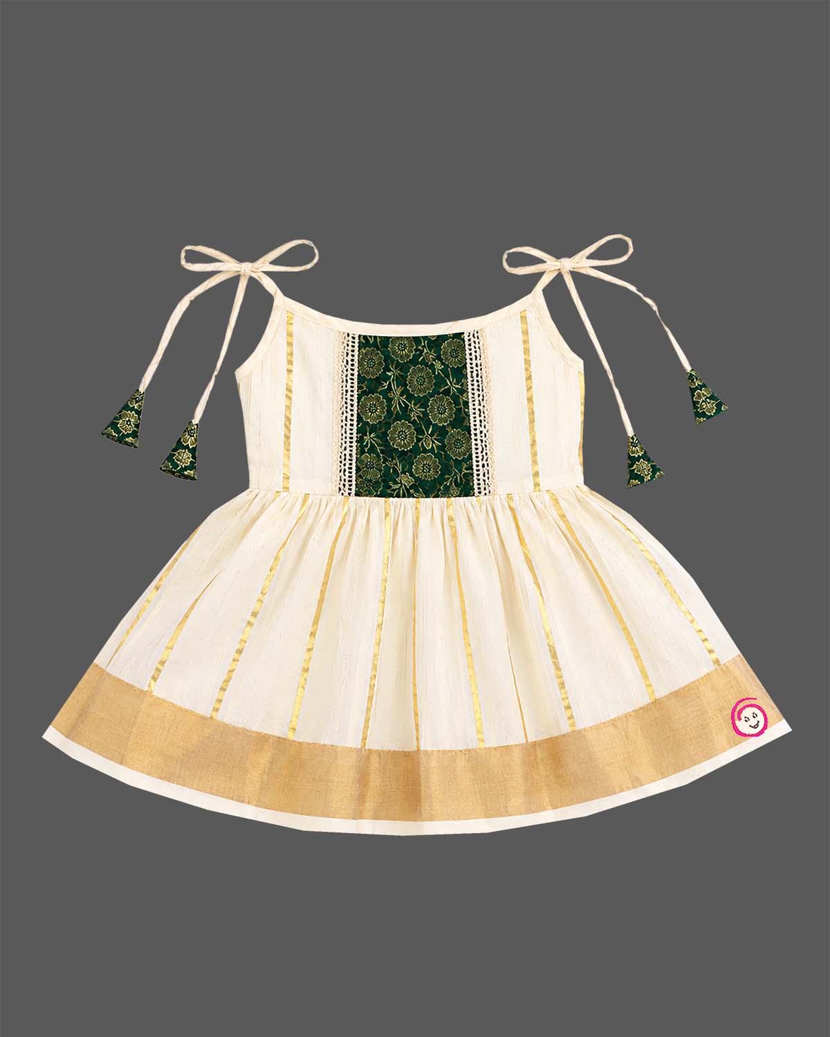 Little princess wearing woven traditional festive outfit featuring shoulder strap tassels and metallic woven trim.