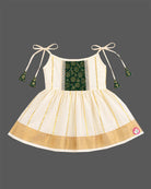 Little princess wearing woven traditional festive outfit featuring shoulder strap tassels and metallic woven trim.