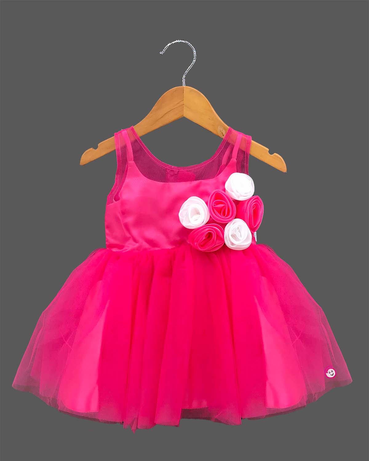 Sleeveless party outfit for toddlers with layered tulle skirt and handcrafted rosette chest appliques.