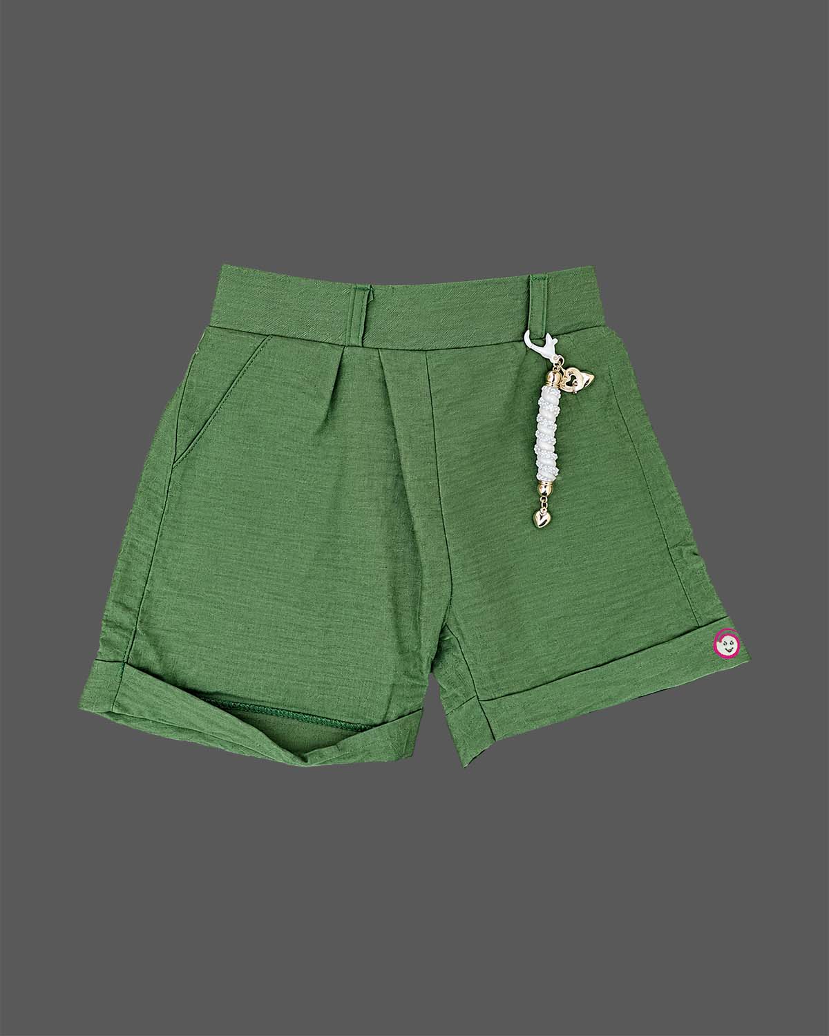 Girls sleeveless embroidered top with scalloped hem paired with pleated cuffed shorts and decorative charm.