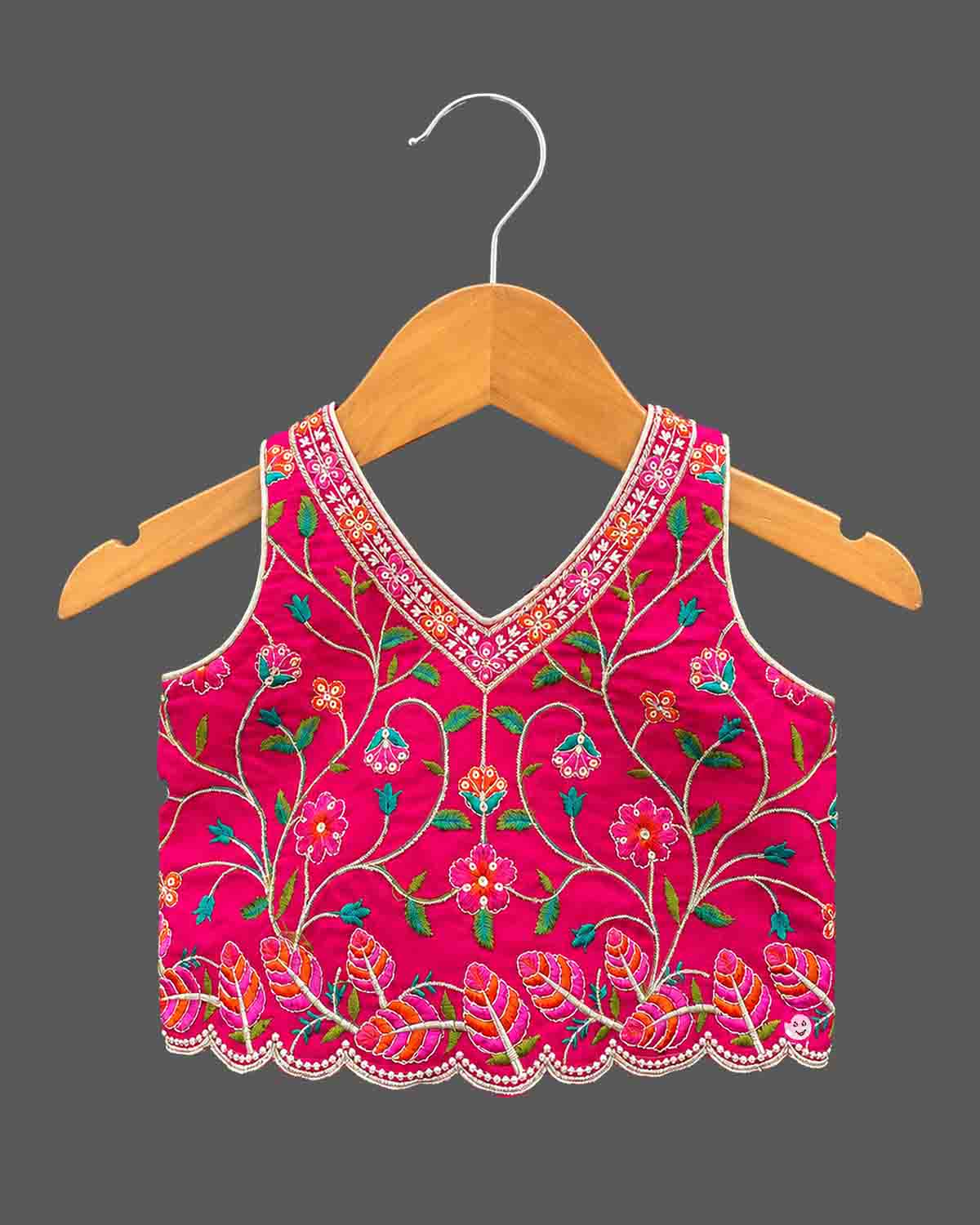 Detailed view of sleeveless embroidered lehenga choli for kids featuring scalloped floral hems.