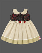 Little one wearing Ajrakh print peter pan collar frock with waist rosette detail and Kasavu border