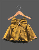 Mustard gold satin party frock for girls featuring an oversized front bow with rhinestone embellishment and flared pleats.