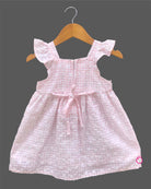 Sleeveless cotton casual frock with a checkered pattern and front bow detail hanging on a hanger.