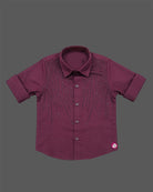 Detailed view of a boys collared party shirt embellished with elegant vertical stud patterns and roll-up sleeves.