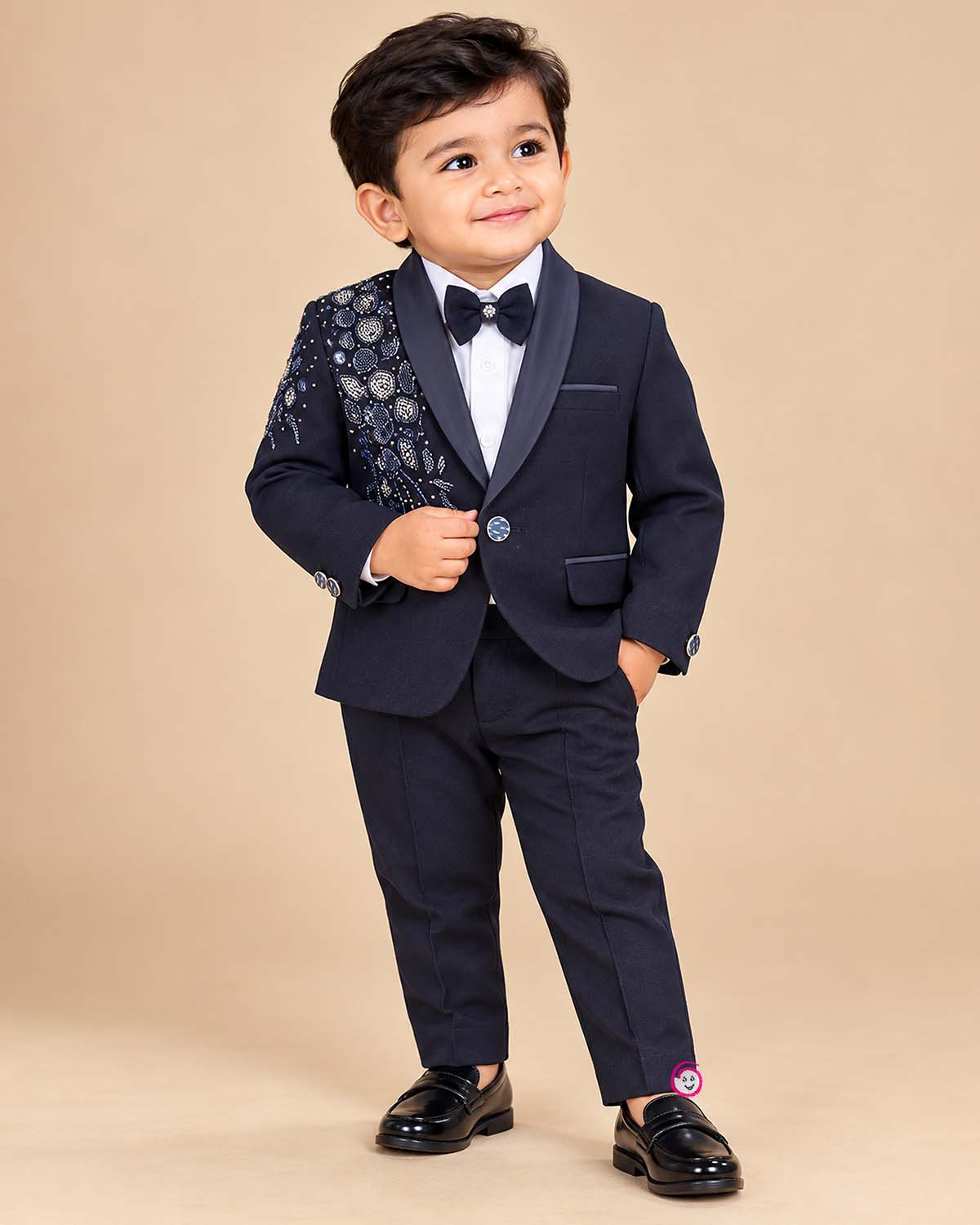 Boys formal tuxedo suit set featuring bead embellished blazer with bowtie and pant.
