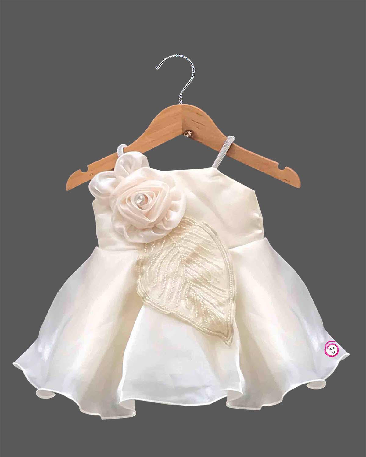 Off-white satin and organza party frock for baby girls featuring a large satin rose, embroidered leaf detail, and pearl embellishments