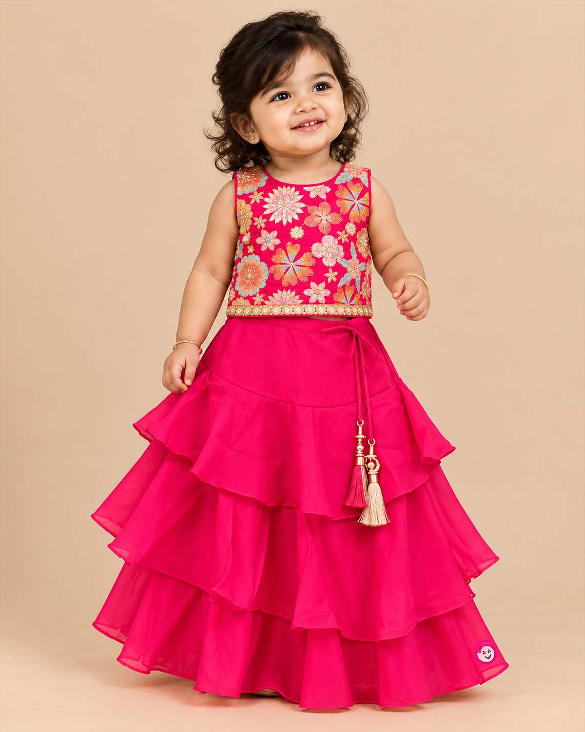 Girls floral embroidered sleeveless choli and tiered ruffle lehenga skirt set with drawstring tassel accents.
