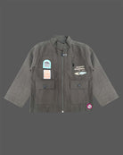 Modern two-piece casual set for toddler boys featuring a zip-front high-neck shirt jacket with graphic patches alongside matching cargo pants.