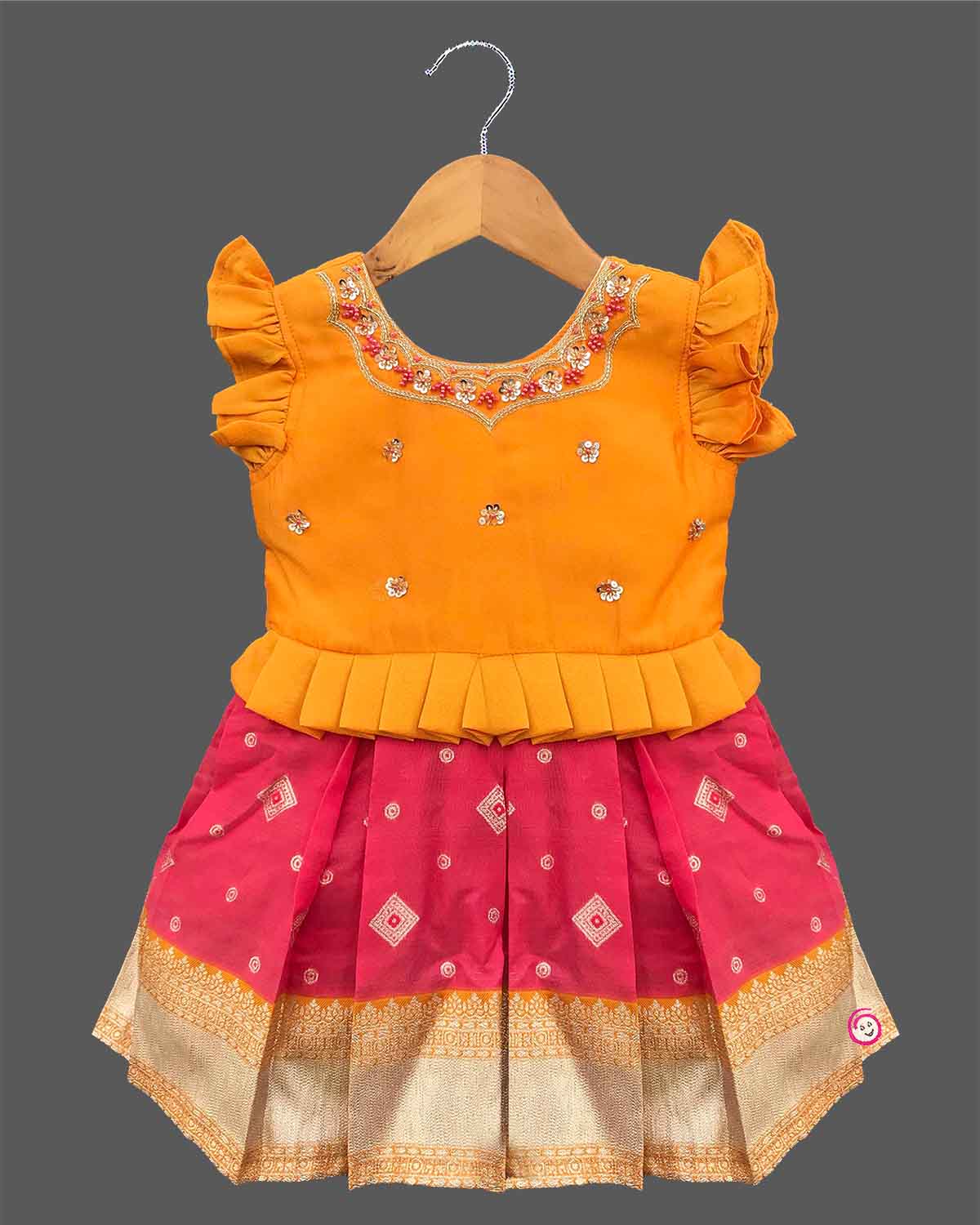 Traditional cotton silk ethnic frock for little ones featuring sequin work neckline ruffle sleeves and zari border