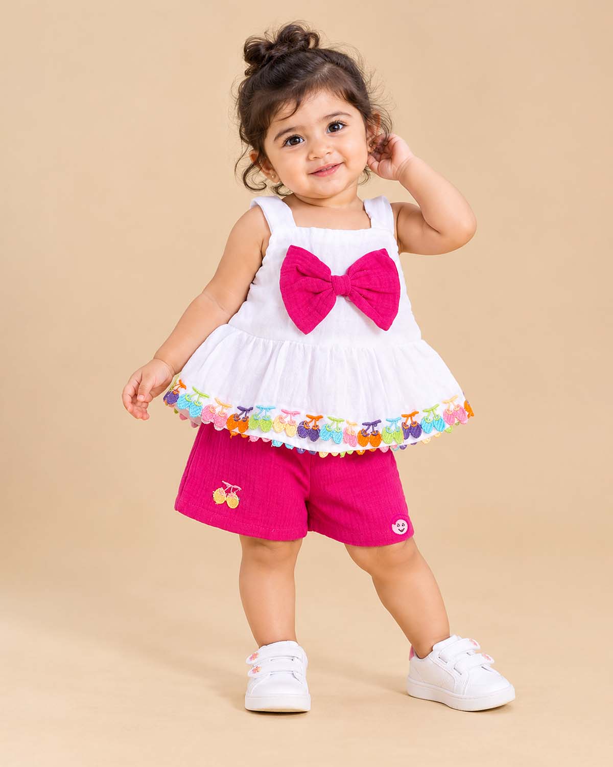 Baby party wear dress set featuring a sleeveless strap top with front bow trim and matching shorts.