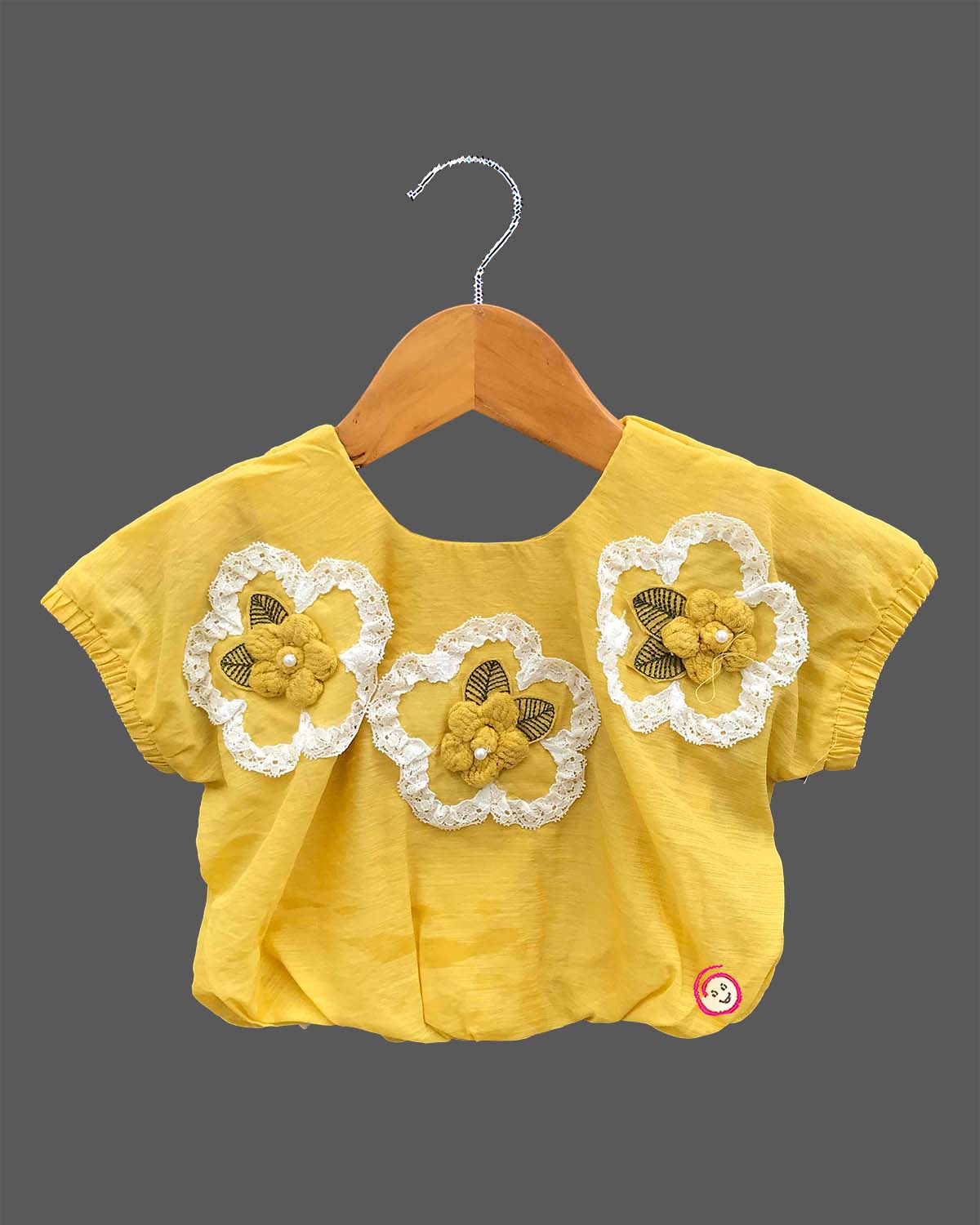 Cap sleeve top with lace flower motifs paired with a tiered embroidered skirt for a young fashionista