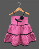 Toddler western frock with shoulder straps, scalloped wave trims, and a floral appliqué motif for celebrations and picnics.