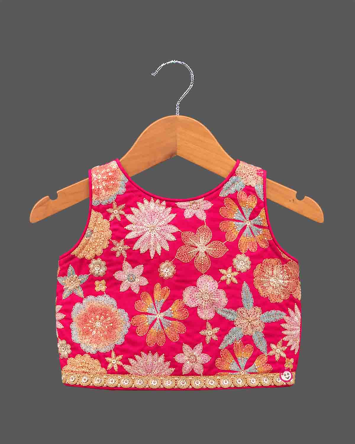 Girls floral embroidered sleeveless choli and tiered ruffle lehenga skirt set with drawstring tassel accents.