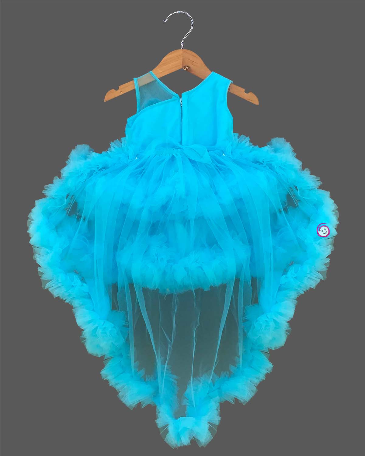 Glittering embellished flower applique party frock for little princess with ruffled high-low net skirt displayed on a wooden hanger.