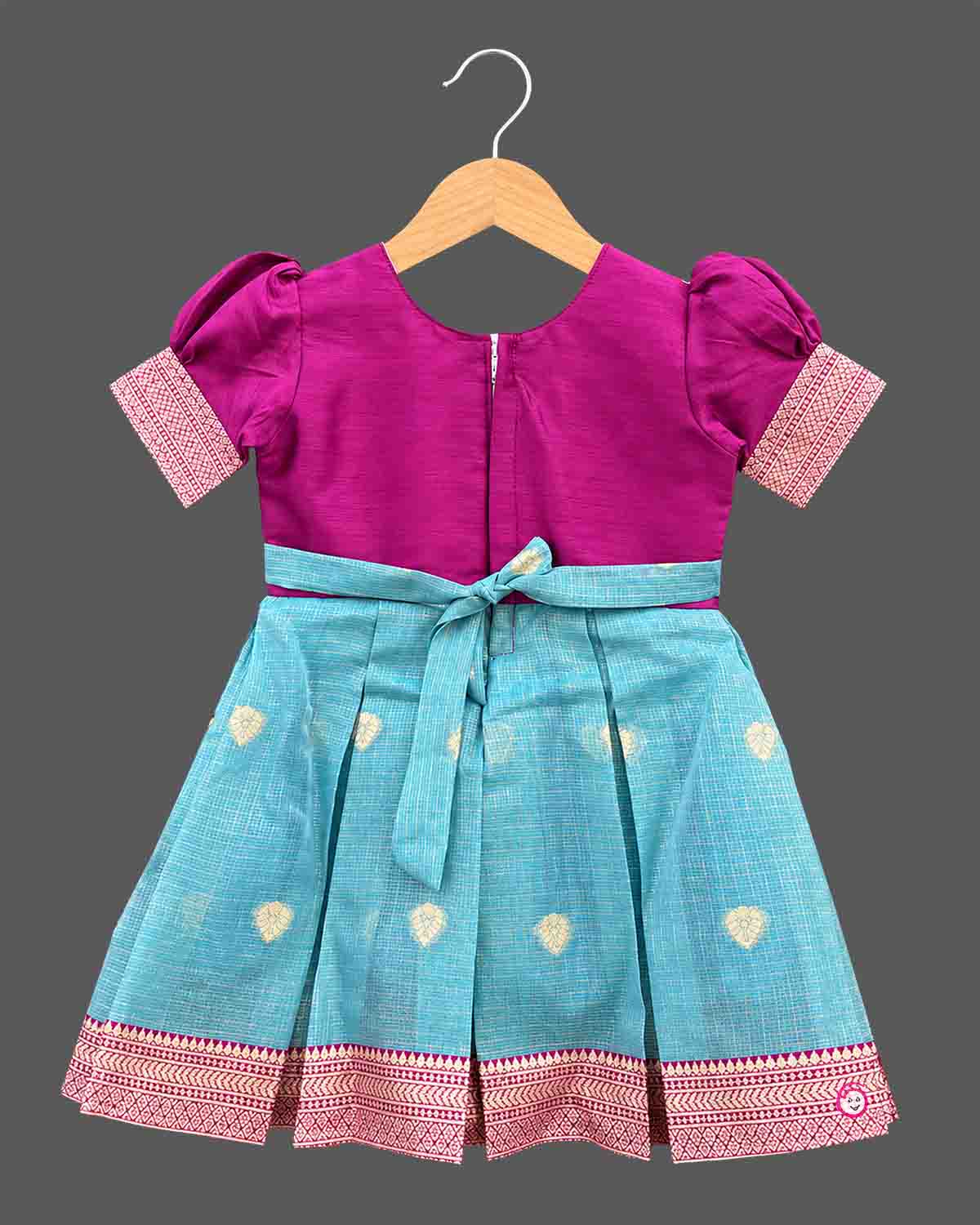 Embroidered pattu frock for baby girl with puffed sleeves, zari border, and box-pleated silhouette.