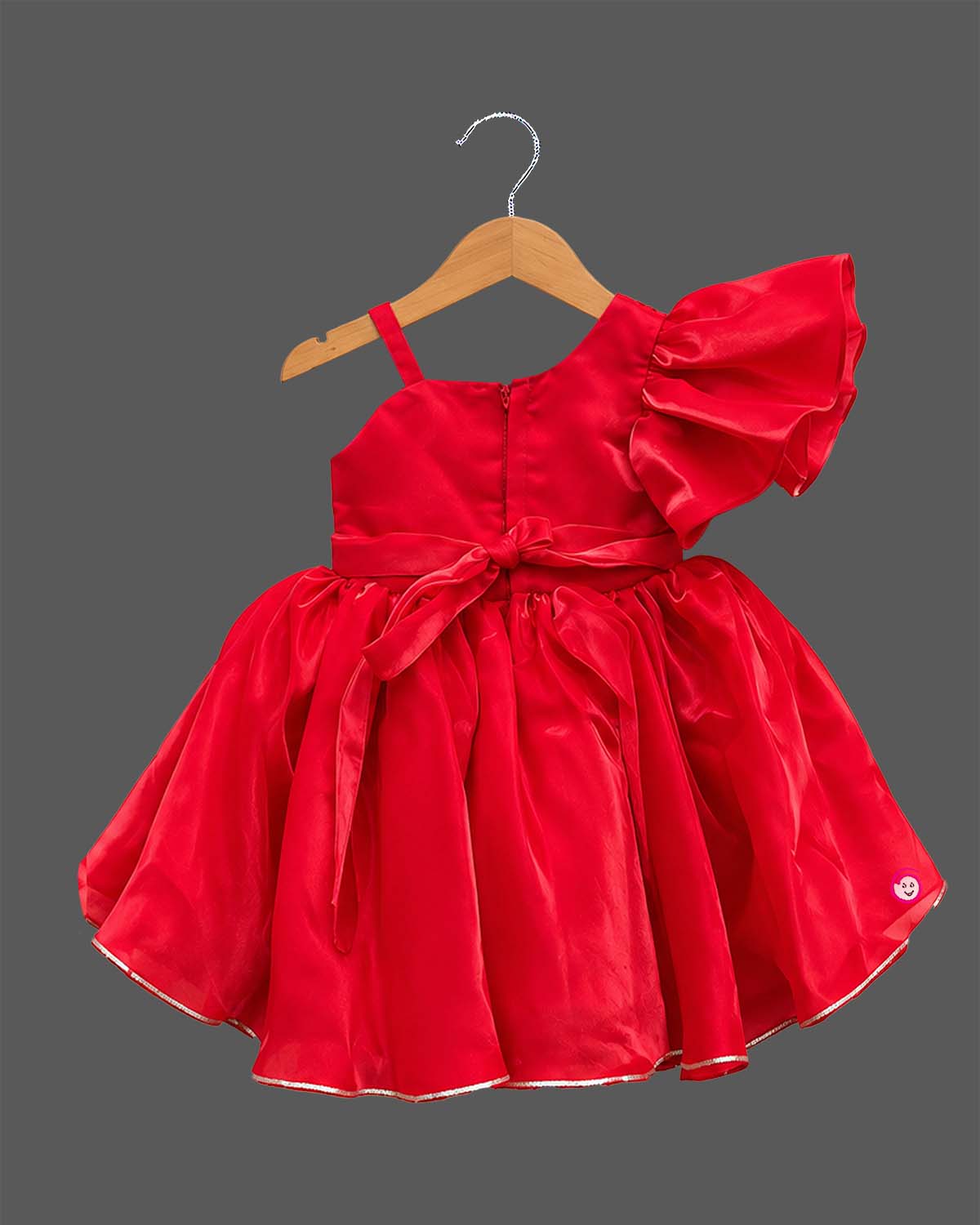 Girls sequin one shoulder frock with dramatic ruffle sleeve, floral waist applique, and flared layered skirt.