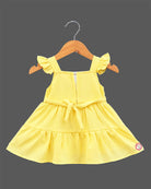Girls smocked tropical frock with frill sleeves, flower applique, and embroidered flared hem.