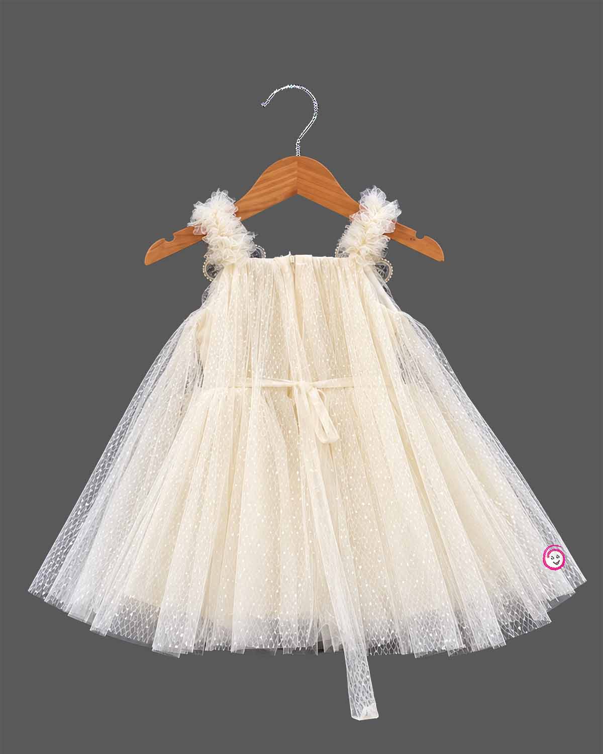 Cream Little Girl Tulle Party Frock with Polka Dots, Flower Details, and Square Neck on Hanger.