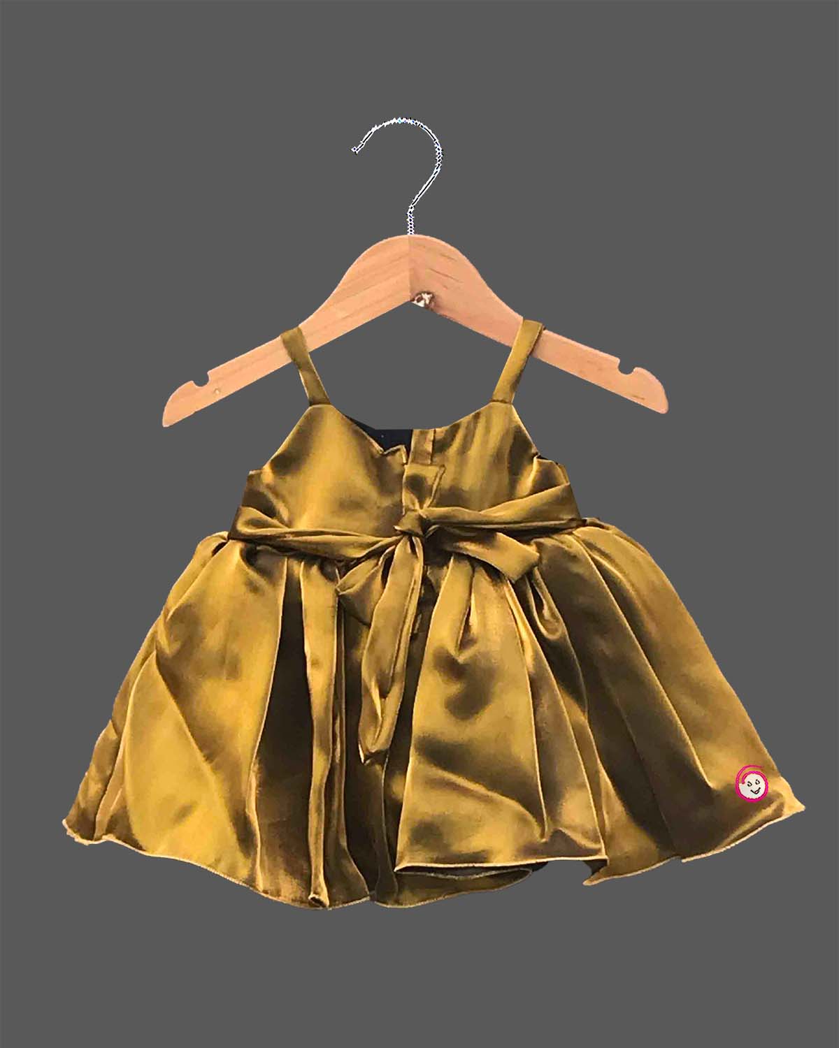 Mustard gold satin party frock for girls featuring an oversized front bow with rhinestone embellishment and flared pleats.