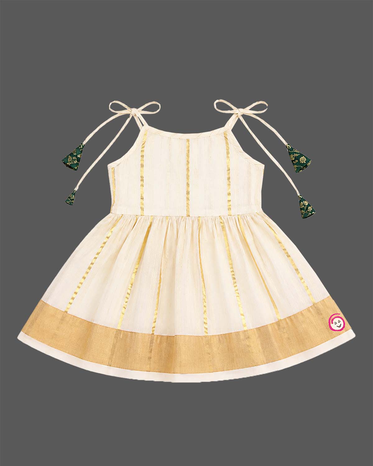 Little princess wearing woven traditional festive outfit featuring shoulder strap tassels and metallic woven trim.
