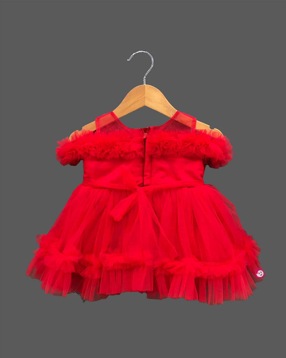 Off-shoulder frill sleeve gown for a little princess with a layered ruffled hemline and sparkling belt embellishment.