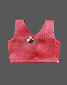 Kids festive wear featuring V neck jacquard blouse with floral brooch detail and zari pleated skirt set