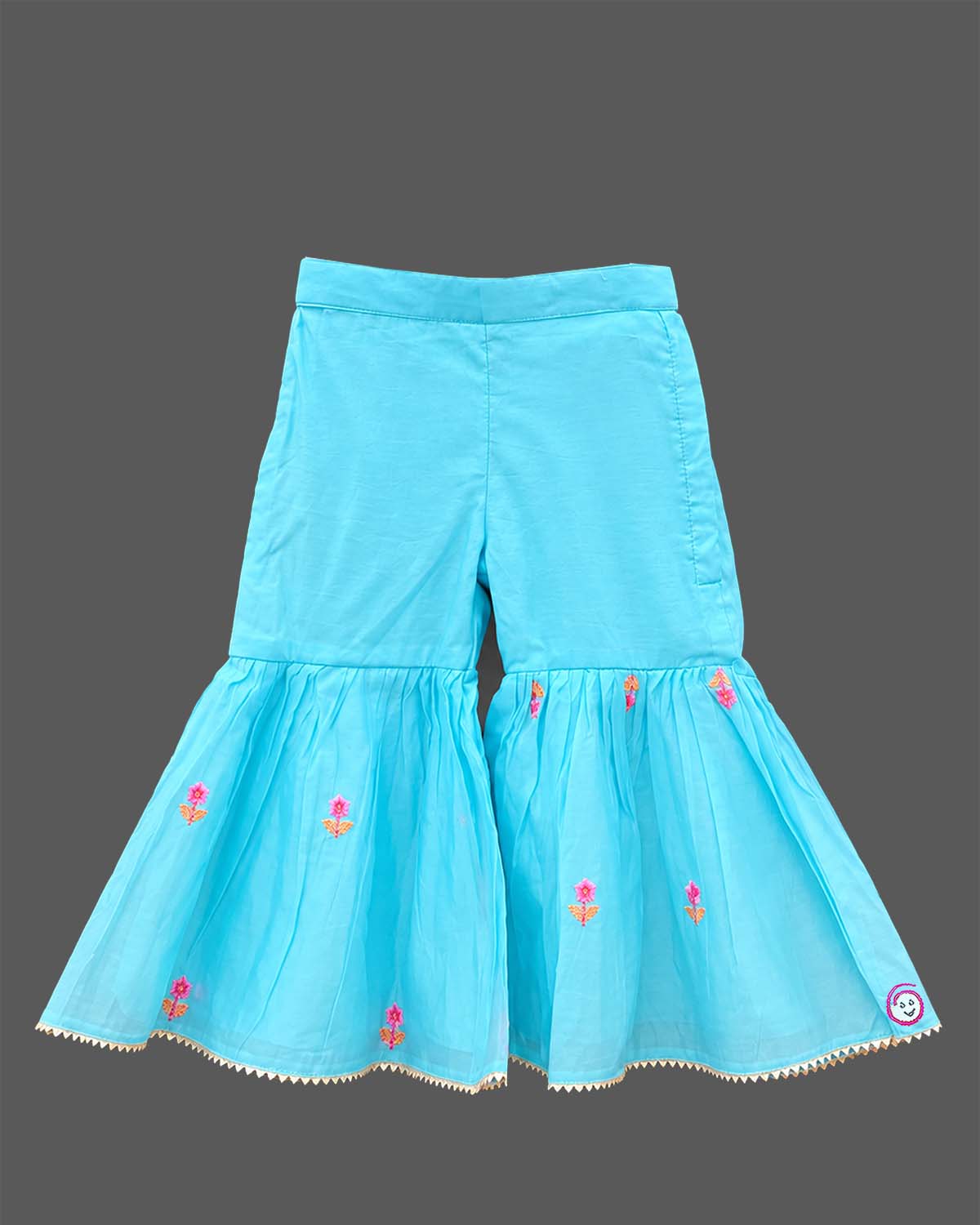 Girls sleeveless embroidered peplum kurti paired with tiered flared sharara pants featuring tassel ties.
