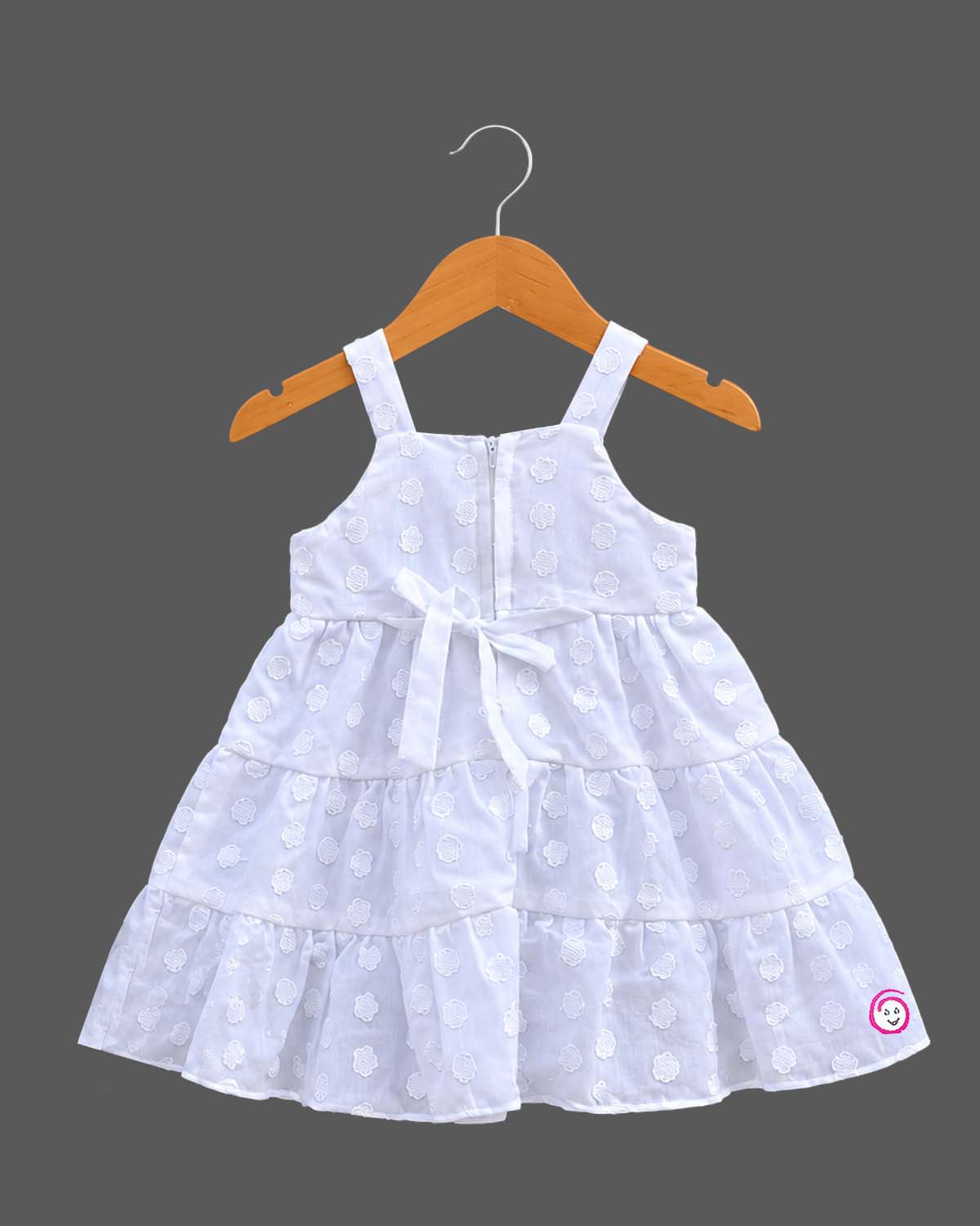 Sleeveless  tiered frock with decorative appliques and casual frock details.