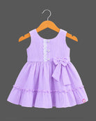 Pleated tiered frocks for baby girl featuring a side bow, lace-trimmed button placket, and round neck