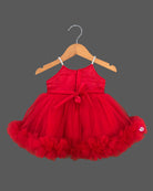 Elegant party frock for little princess with a grand 3D rose chest piece, sparkling spaghetti straps, and a dense ruffled net hemline hung on a wooden hanger.