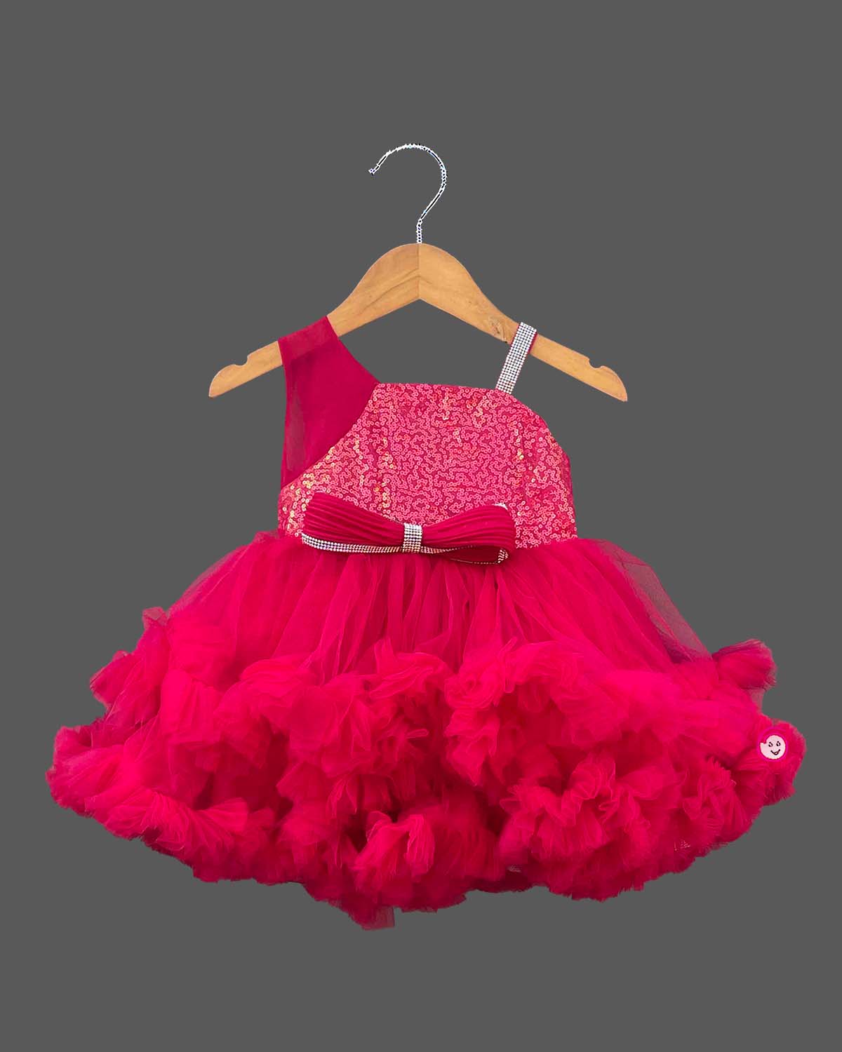 Sequined high-low baby party wear dress with layered tulle ruffle skirt and embellished strap.