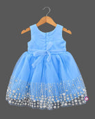 Sleeveless tulle net baby party wear dress with pearl rosette waist and sequined floral hemline.