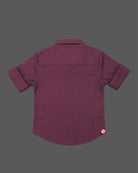 Detailed view of a boys collared party shirt embellished with elegant vertical stud patterns and roll-up sleeves.