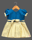 Toddler kids silk cotton frock ethic wear featuring embroidered round neck, puffed sleeves, and bordered skirt.