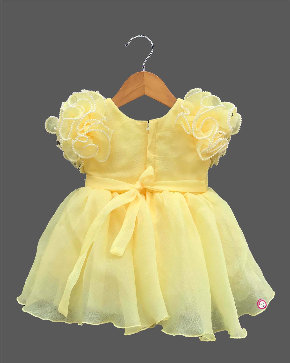 Ornate ruffled-sleeve celebration dress for a little diva with pearl-accented edges and a center floral motif.