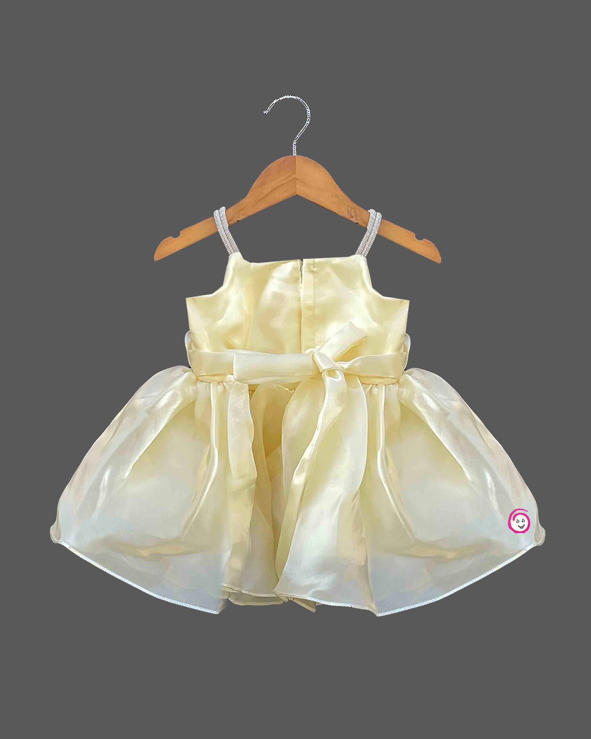 Baby party wear dress featuring satin rosette appliqués, embellished shoulder straps, and a flared organza skirt.