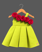 One-shoulder pleated party frock adorned with cascading fabric roses and green leaf details for festive celebrations.