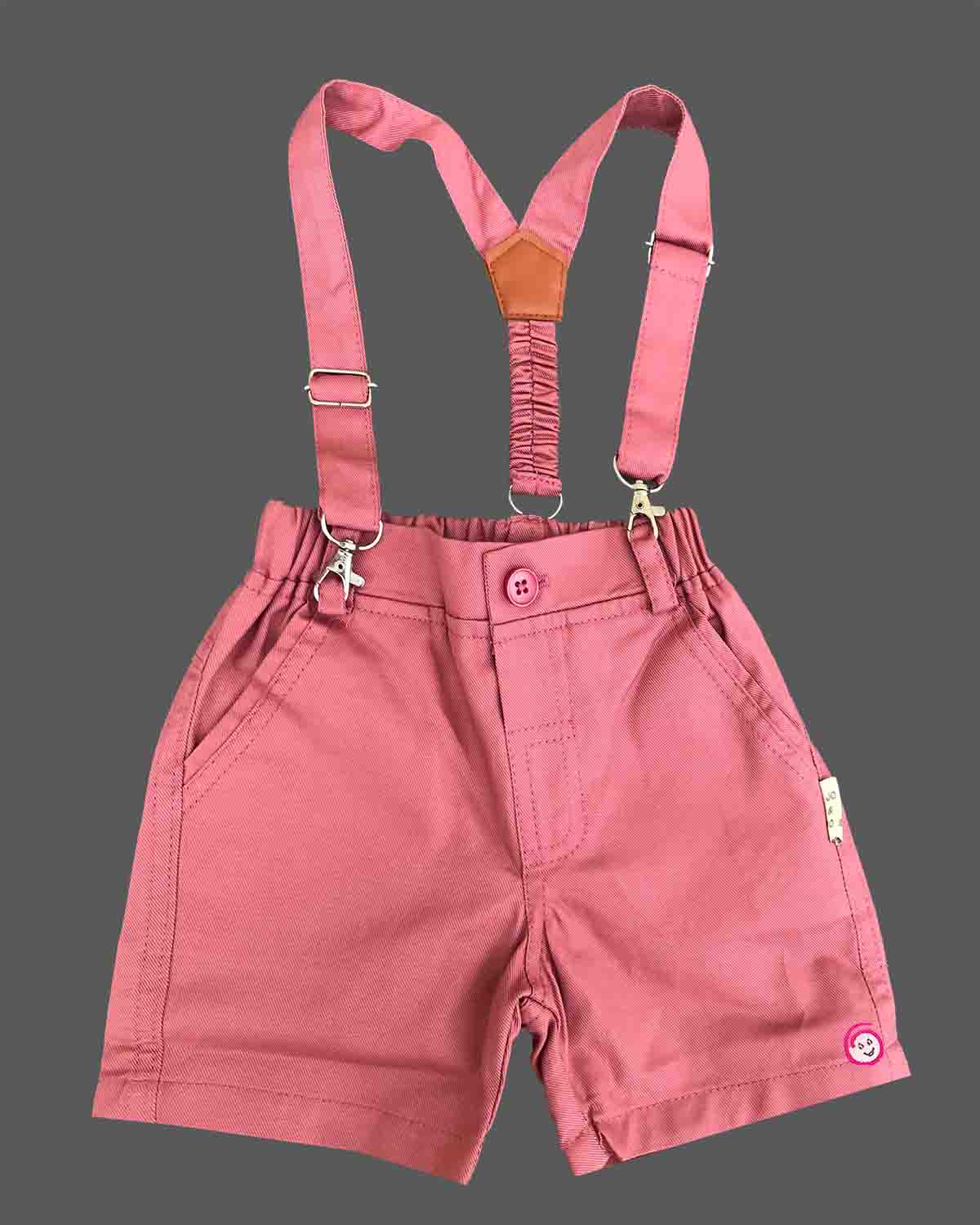 Dapper toddler boys ethnic ensemble featuring a collared printed shirt with a bow tie and matching suspender shorts.