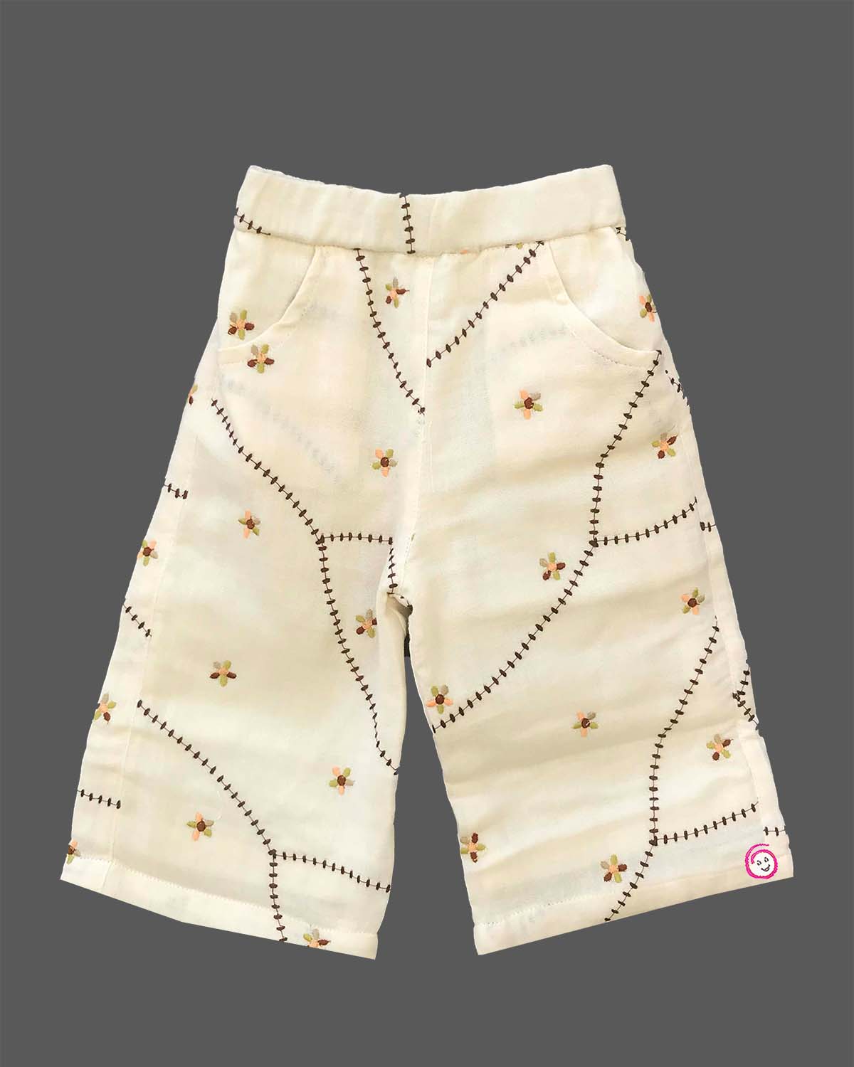 A cute patterned cotton co-ord set for baby girls featuring a sleeveless peplum top with ruffle straps and matching pants on a hanger.