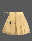 Young fashionista wearing traditional festive two-piece set featuring ribbon rose detail and pleated zari striped skirt.