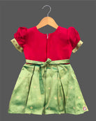 Detailed shot of a baby girl ethnic silk frock featuring traditional floral embroidery and puff sleeves.
