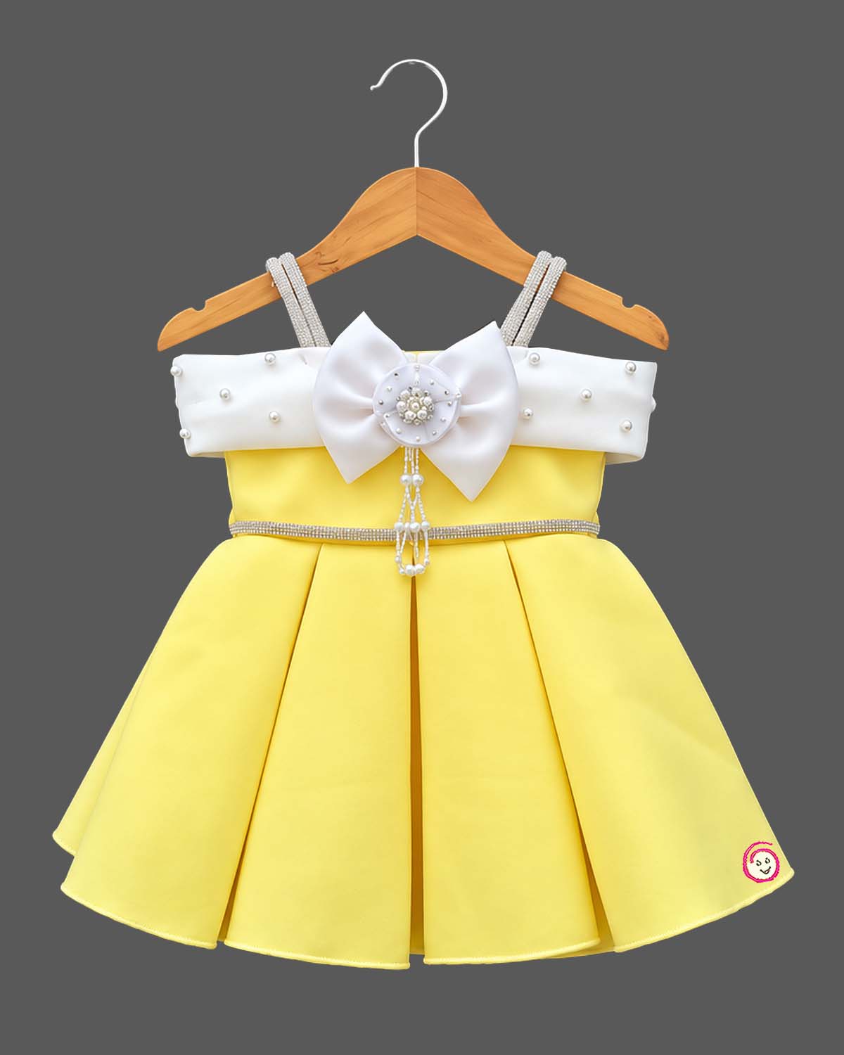 Scuba frock for baby girl featuring structured box pleats and pearl-embellished bow bodice.