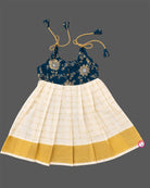 Young princess wearing shoulder tie-up brocade yoke frock with Kasavu pleated skirt for Onam