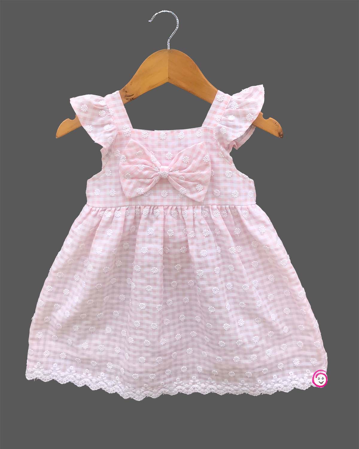 Sleeveless cotton casual frock with a checkered pattern and front bow detail hanging on a hanger.